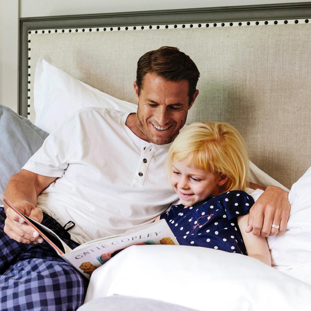 Father and child reading on The Fairmont Bed