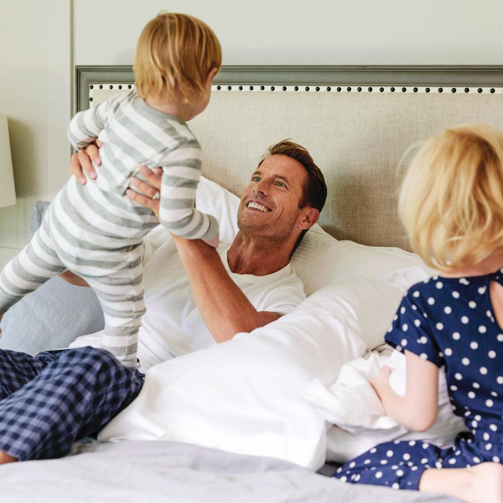 Father and kids playing on The Fairmont Bed