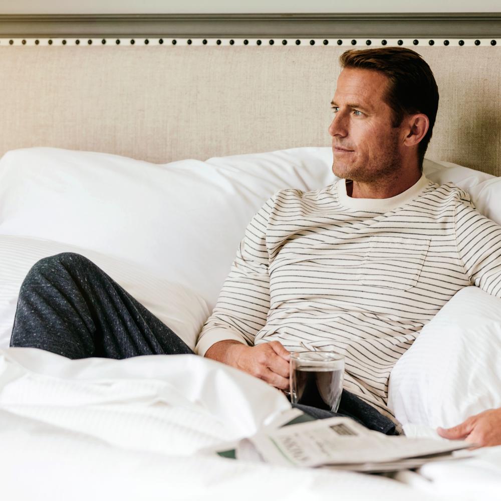 Man drinking coffee on The Fairmont Bed